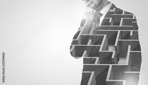 Konstfotografi Young businessman in suit standing with maze graphic