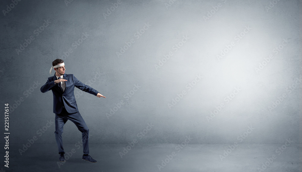 Small karate man fighting in an empty grey copy space Small karate man fighting in an empty grey copy space