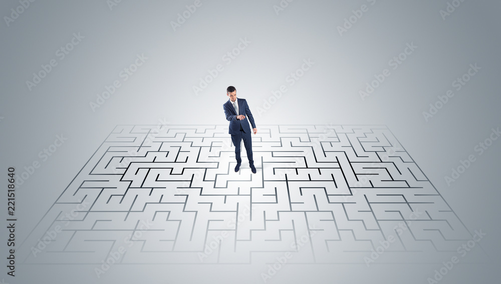 Elegant businessman looking for a solution in a middle of a maze
Elegant businessman looking for a solution in a middle of a maze