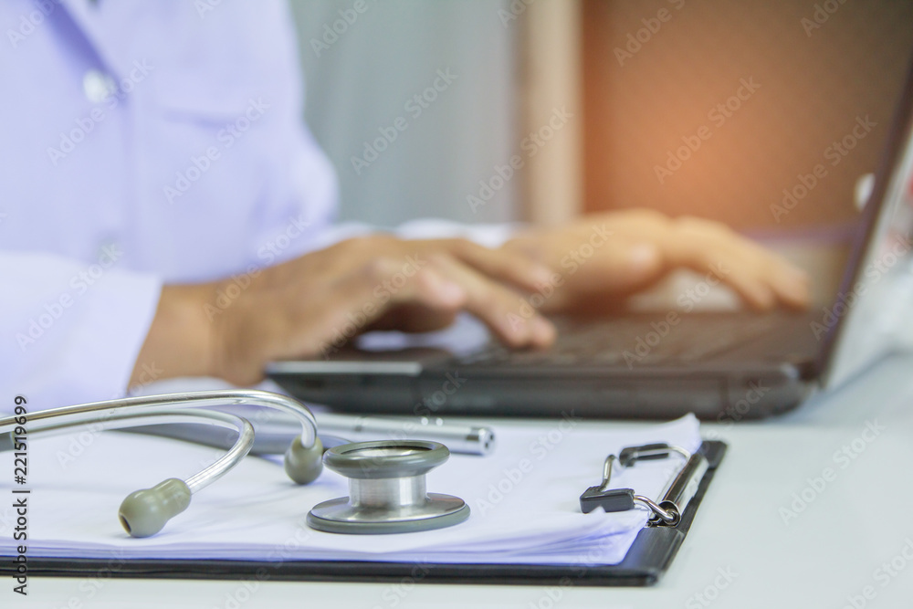 doctor using digital labtop computer medical working information with stethoscope on desk.