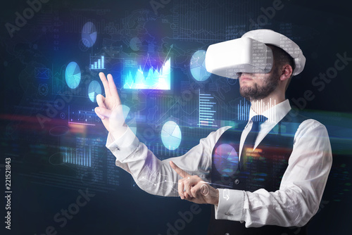Elegant businessman in DJI goggles handling 3D reports and charts around him 