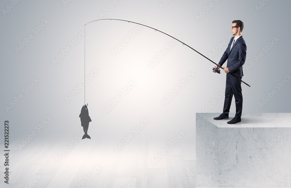 Young businessman fishing golden fish from the top of a building
Young businessman fishing golden fish from the top of a building