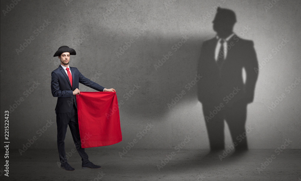 Obraz premium Businessman standing with red cloth on his hand and his shadow on the background 
