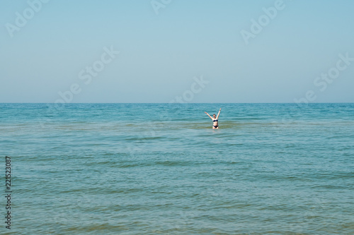 A young girl standing in the water.