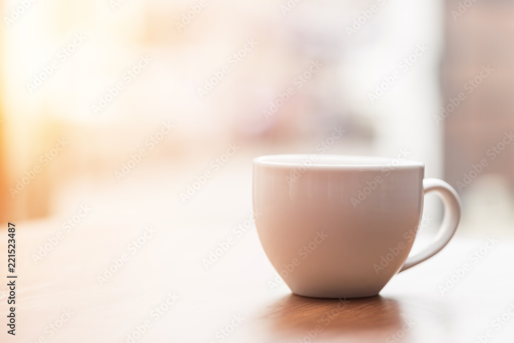 Coffee cup on wooden table in the morning with gold light feeling warm,Selective focus