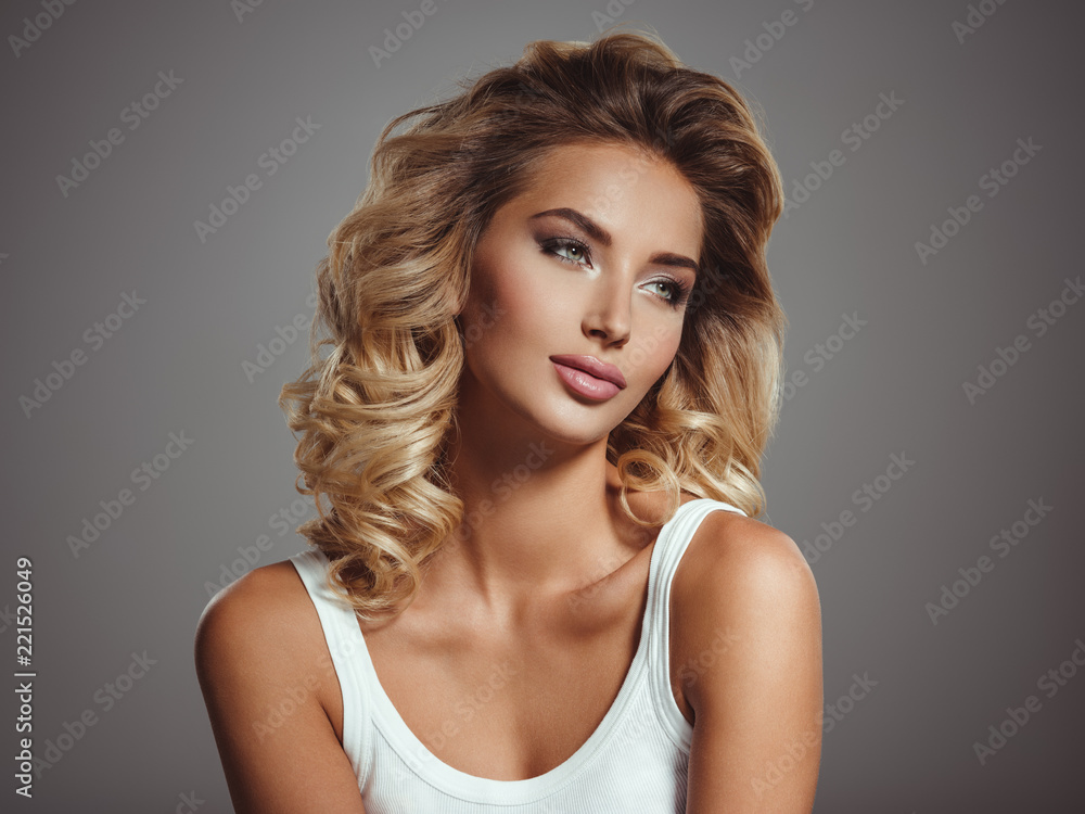 Obraz premium Photo of a beautiful young blond girl with curly hair
