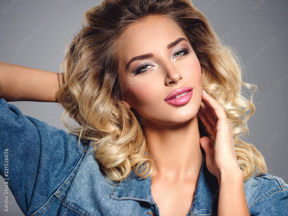 Fototapeta premium Photo of a beautiful young blond girl with curly hair