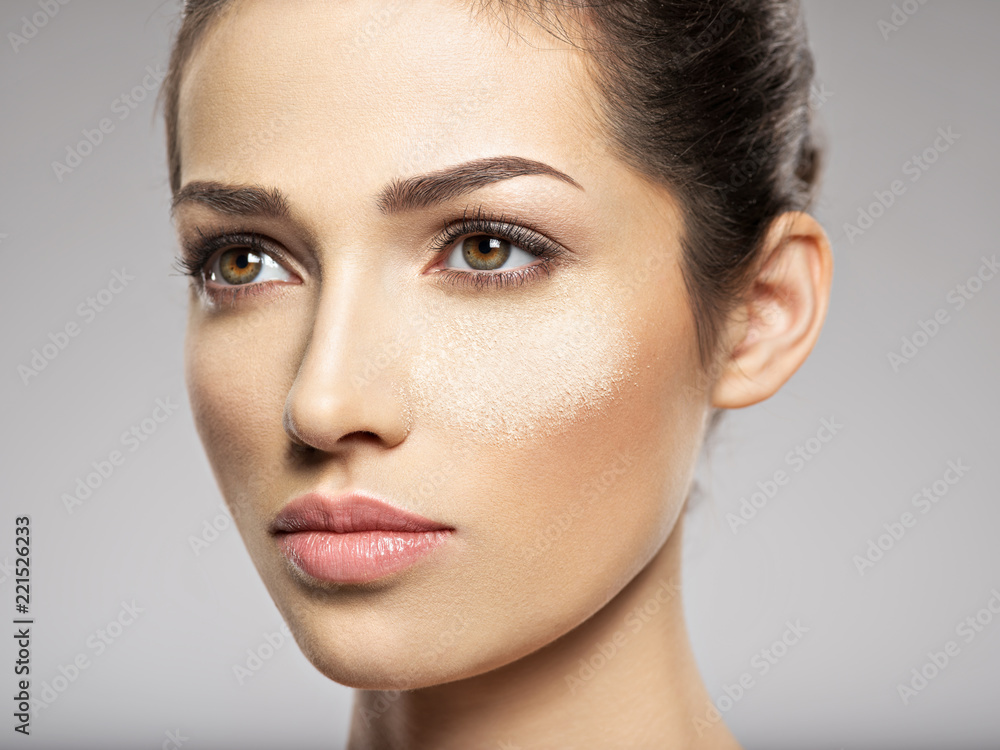 dry cosmetic makeup powder is on the female face. dry cosmetic makeup powder is on the female face.
