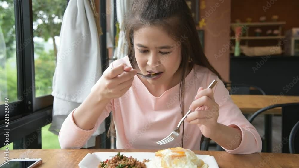 Beautiful asian woman eating Thai food for lunch at restaurant
