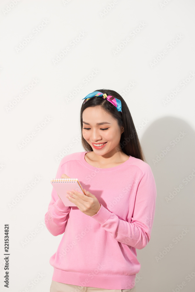 Portrait with copy space empty place of pretty, trendy, charming, nice, sexy, cute woman isolated on white background organizing her day, having notebook and pencil in hands Portrait with copy space empty place of pretty, trendy, charming, nice, sexy, cute woman isolated on white background organizing her day, having notebook and pencil in hands