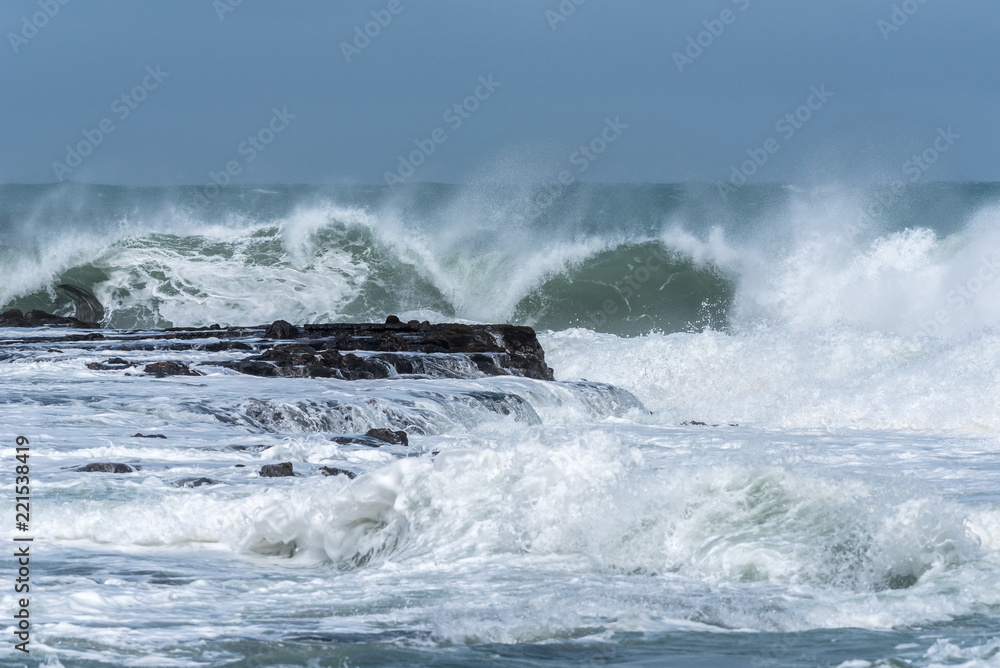 Waves crashing into the rocky headland between Porpoise Bay and Curio Bay on the Catlins coast, Otago, New Zealand.