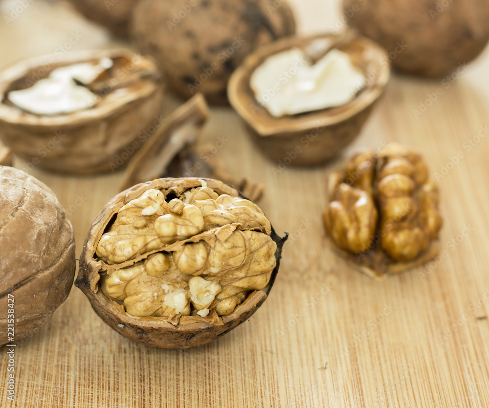 Fototapeta premium Healthy food safety concept:Walnuts kernels on dark desk with color background