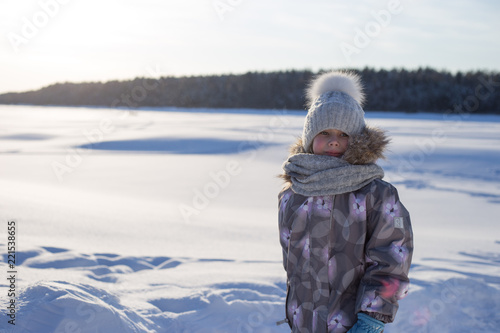 Winter portrait of happy little girl wearing knitted hat and scarf. Family fashion concept.