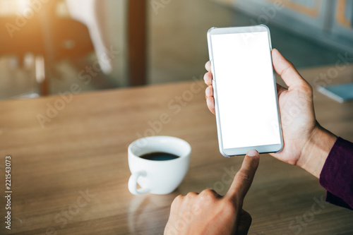 Mockup image of man's hands holding white mobile phone with blank screen technology and lifestyle concept.