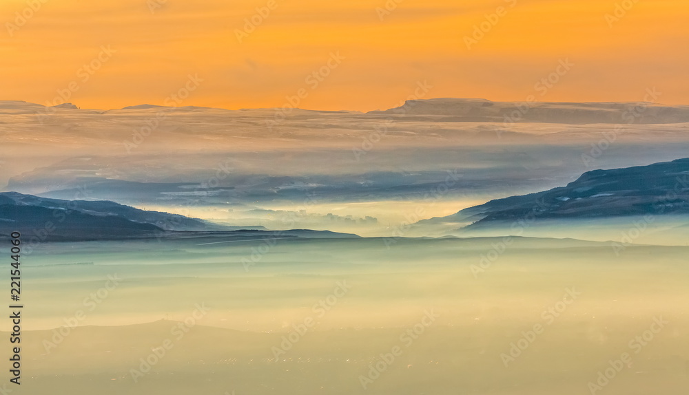 Mountains in the fog, haze. The Main Caucasian Range. Multicolored background. Mountains at sunset. Winter fog. Mountains in the fog, haze. The Main Caucasian Range. Multicolored background. Mountains at sunset. Winter fog.