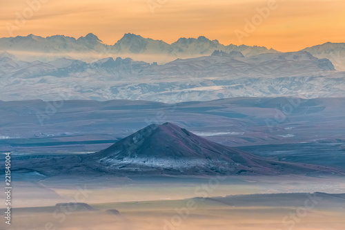 Mountains in the fog, haze. The Main Caucasian Range. Multicolored background. Mountains at sunset. Winter fog.