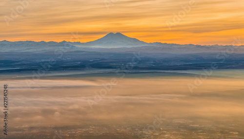 Mountains in the fog, haze. The Main Caucasian Range. Multicolored background. Mountains at sunset. Winter fog. © Фёдор Лашков