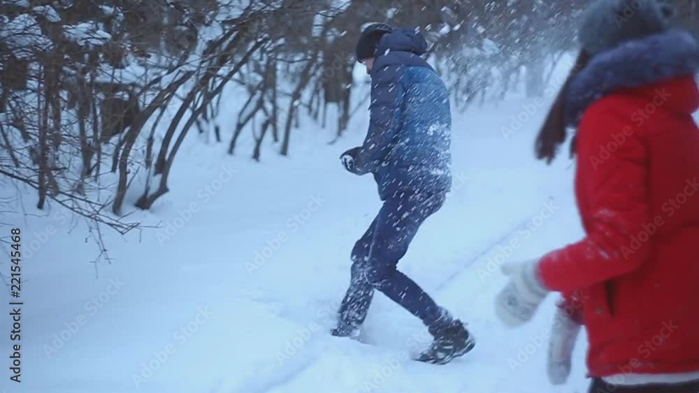 A young couple walk in winter Park, a guy and a girl play in the snow in the Park. A young couple walk in winter Park, a guy and a girl play in the snow in the Park.