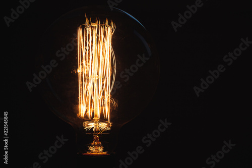 Vintage stylized tungsten lamp glowing at night