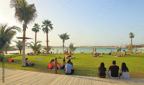 La Mer in Dubai, UAE - May 06, 2018: People rest on the beach at sunset. It is a new beachfront district with shopping and restaurants in Jumeirah. DUBAI, UAE -May 06, 2018 .