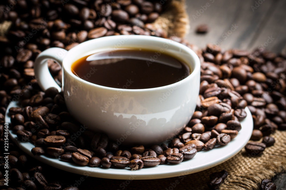 Coffee cup and beans on a rustic background. Coffee Espresso and a piece of cake with a curl. Cup of Coffee and coffee beans on table. Coffee cup and beans on a rustic background. Coffee Espresso and a piece of cake with a curl. Cup of Coffee and coffee beans on table.