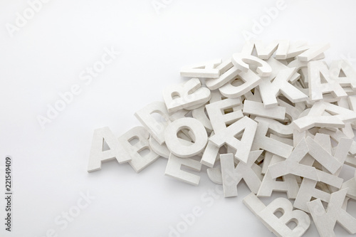 Pile of white painted wooden letters. Typography background composition. photo