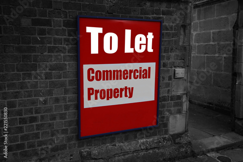 Foto To let with commercial property written on a sign attached to a brick wall with