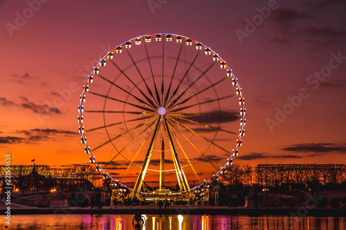Illuminated ferris wheel with colorful sunset. photo