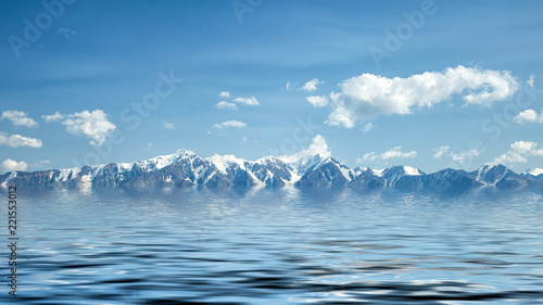 A landscape view of beautiful fhigh mountains covered with ice and snow, in the foreground the cold blue sea.