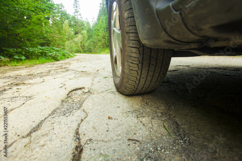 car tire and cracked damaged road in the forest