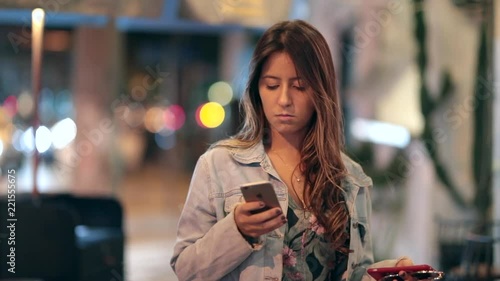 Girl using cellphone at night. Young woman typing on smartphone in the street2 photo