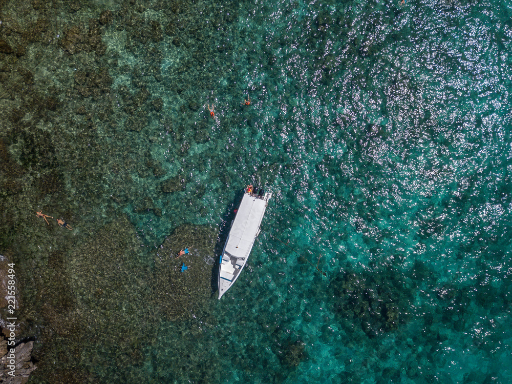 People Snorkeling in Tropical Sea near Yacht. Aerial View People Snorkeling in Tropical Sea near Yacht. Aerial View
