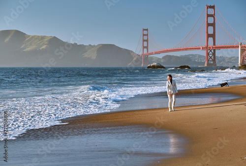 Canvas Print Woman walking on beach near Golden Gate Bridge