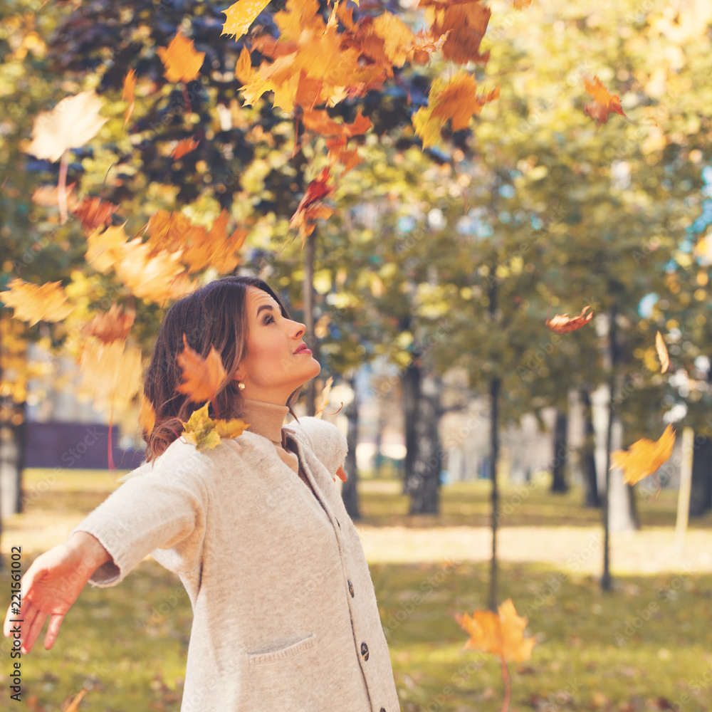 Cheerful woman throwing fall maple leaves in sunny day outdoors, autumn portrait Cheerful woman throwing fall maple leaves in sunny day outdoors, autumn portrait