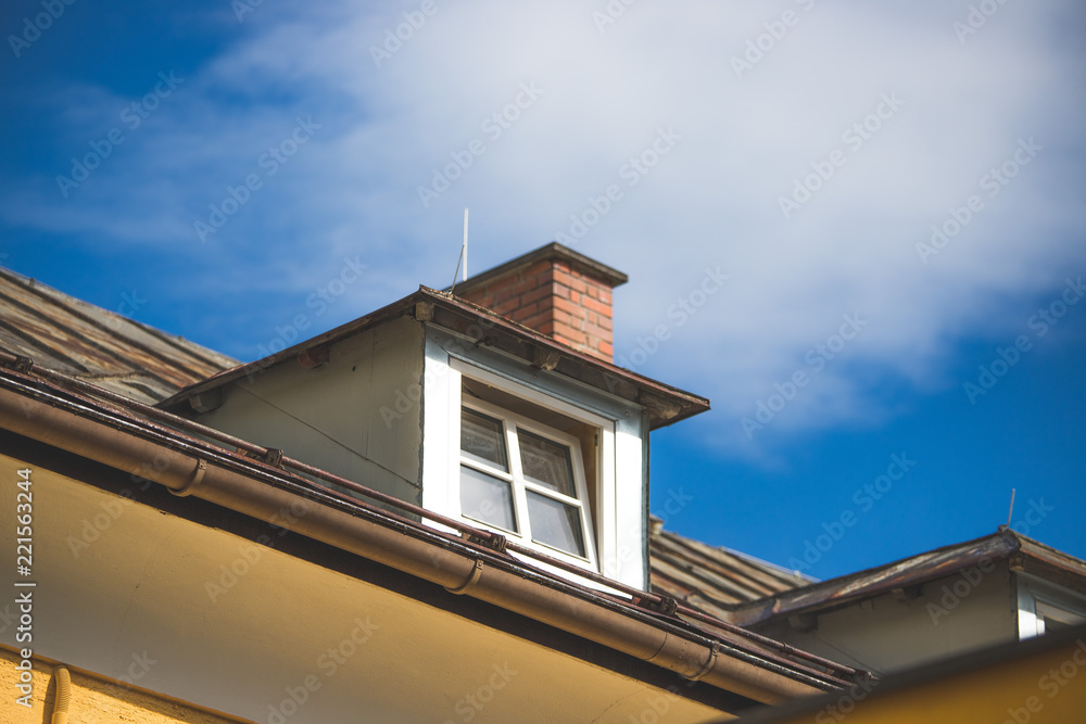 Dachfenster eines Hauses, blauer Himmel