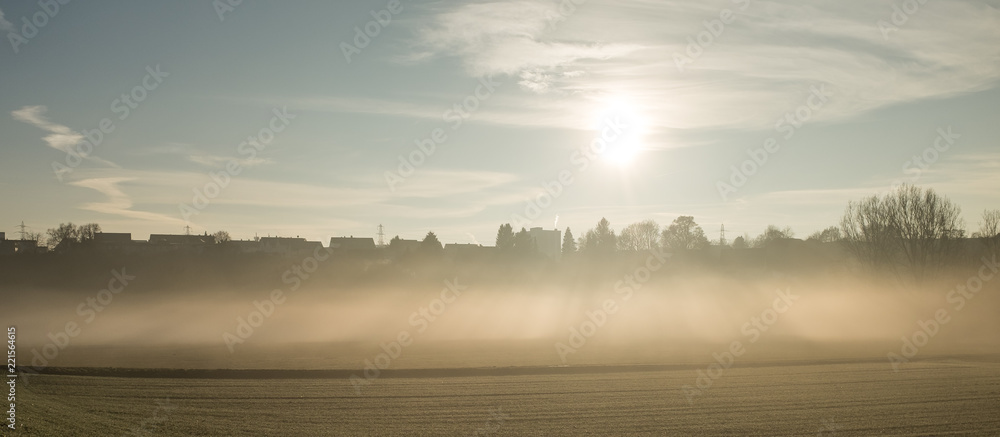 Fototapeta premium Sonne strahlt durch Bodennebel auf weites Feld bei Pliezhausen