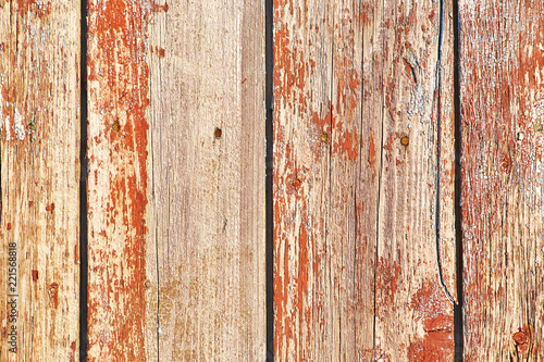 Old wooden background of vertical boards with peeling red color