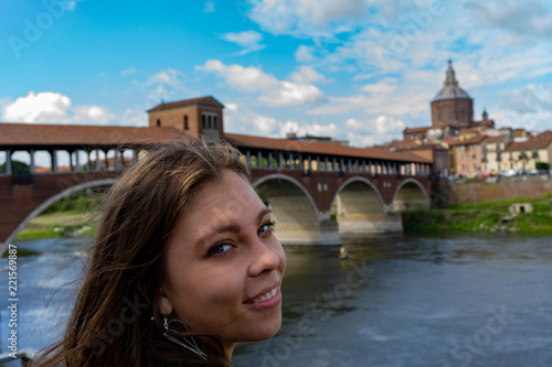 Blonde girl smiling near Ponte Coperto in Pavia, Lombardy, Italy