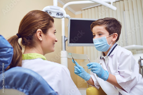 A boy kid is a dentist with a patient at a dental clinic.