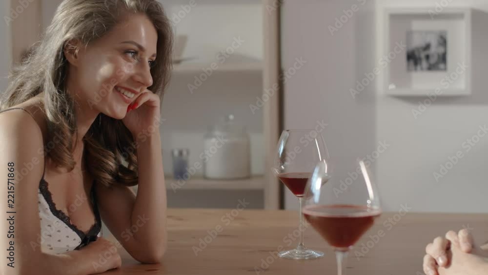 Conversation in cafe between sexy woman and man, people sits at the cafe table, hold glasses of wine in their hands and talk to each other, woman and man on a date