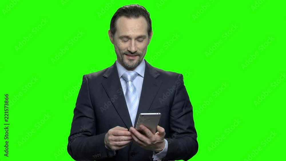Businessman taking out phone from his jacket. Responding to message. Green screen hromakey background for keying. Businessman taking out phone from his jacket. Responding to message. Green screen hromakey background for keying.