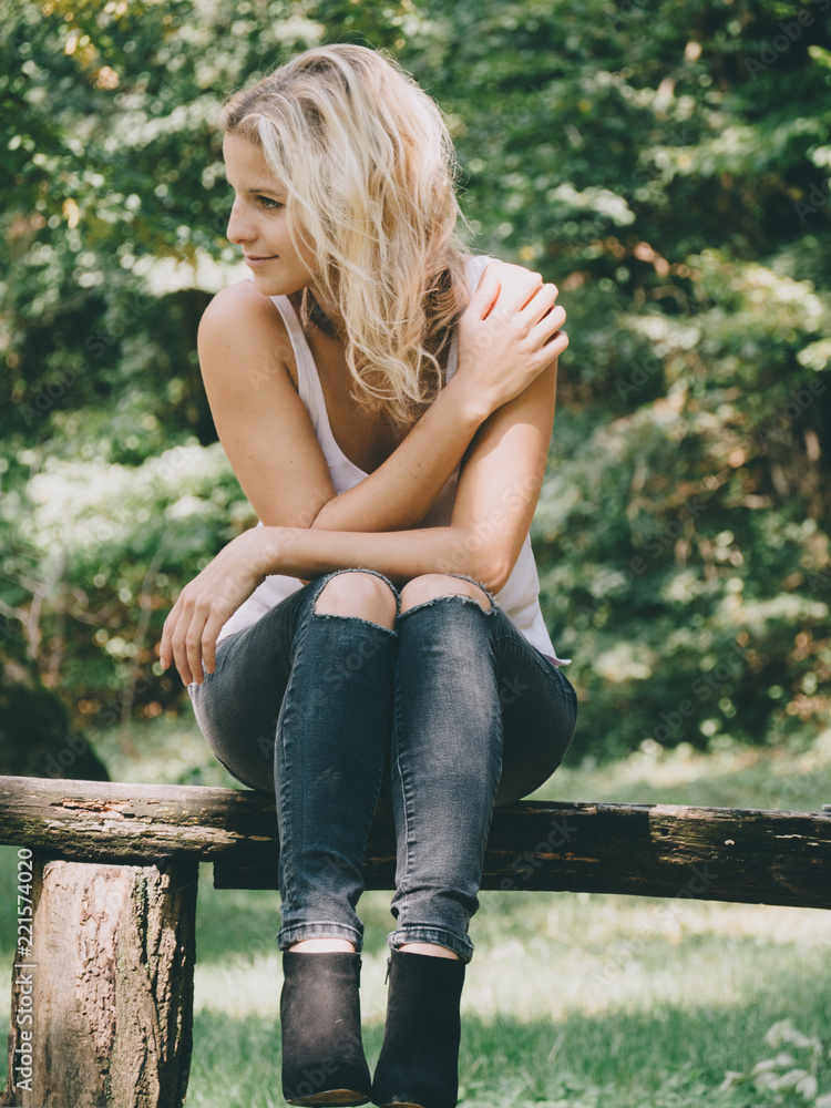 Beautiful blonde woman sitting at park outdoor Beautiful blonde woman sitting at park outdoor