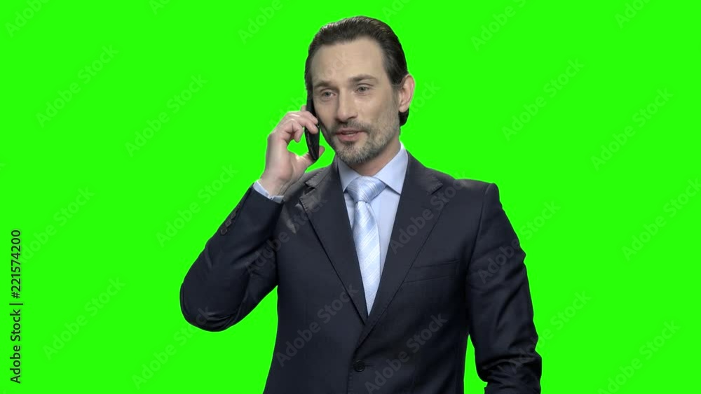 Businessman making profitable agreement using phone. Happy mature man in suit rejoicing success. Green screen hromakey background for keying. Businessman making profitable agreement using phone. Happy mature man in suit rejoicing success. Green screen hromakey background for keying.