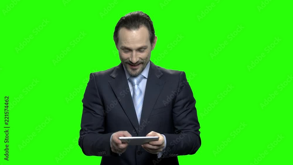 Portrait of man in business suit enjoying mobile games. Green screen hromakey background for keying. Portrait of man in business suit enjoying mobile games. Green screen hromakey background for keying.