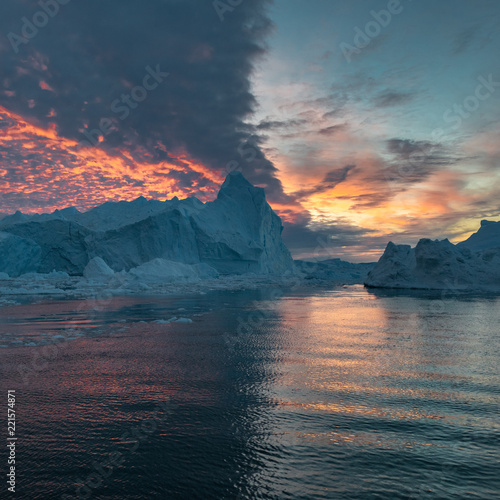 Fototapeta Grenlandia o północy Zachód słońca chmury odzwierciedlają góry lodowe w czterech kwartałach