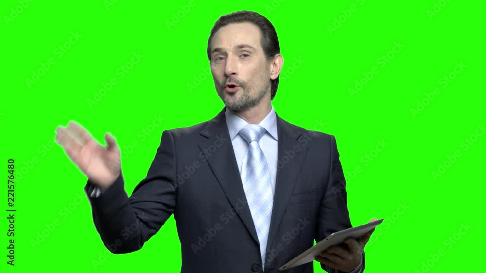 Business coach with tablet during seminar. Talking and explaining. Green hromakey background for keying. Business coach with tablet during seminar. Talking and explaining. Green hromakey background for keying.