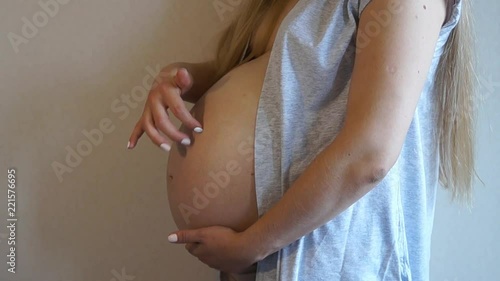 Woman touching her pregnant belly. Pregnant girl. Pregnant woman caressing her tummy