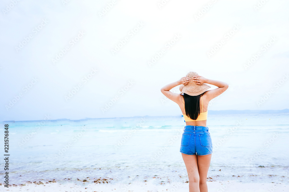 Sexy young woman with red bikini standing holding yellow heart-shaped sunglasses near the blue sea, It is a comfortable and relaxing feeling this summer. Sexy young woman with red bikini standing holding yellow heart-shaped sunglasses near the blue sea, It is a comfortable and relaxing feeling this summer.
