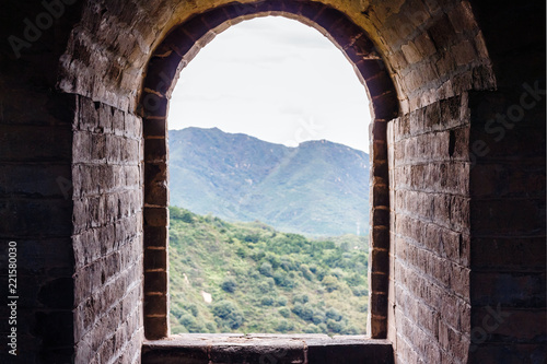 Stone window with a view of the mountain. View from the old fortress in the Great Wall of China