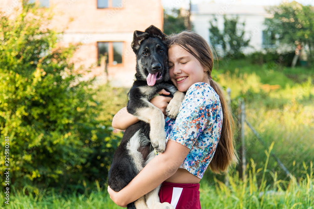 Cute teenage girl hugging a german shepherd puppy. Cute young woman with a puppy dog in nature. Cute teenage girl hugging a german shepherd puppy. Cute young woman with a puppy dog in nature.
